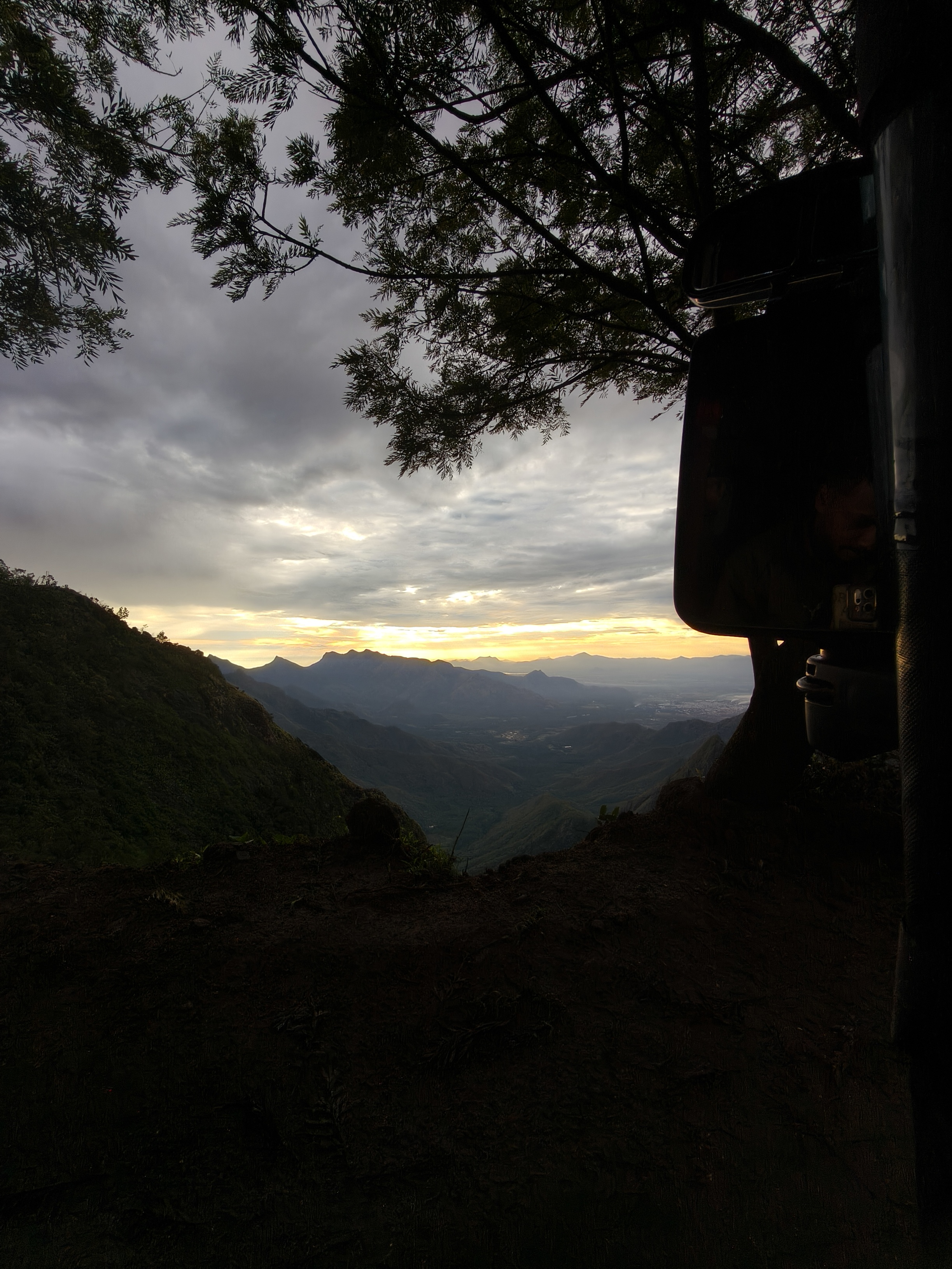 Kolukkumalai sunset with mountain silhouettes and glowing orange clouds